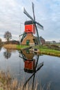 Traditional red wip windmill reflected in water, Netherlands landscape Royalty Free Stock Photo